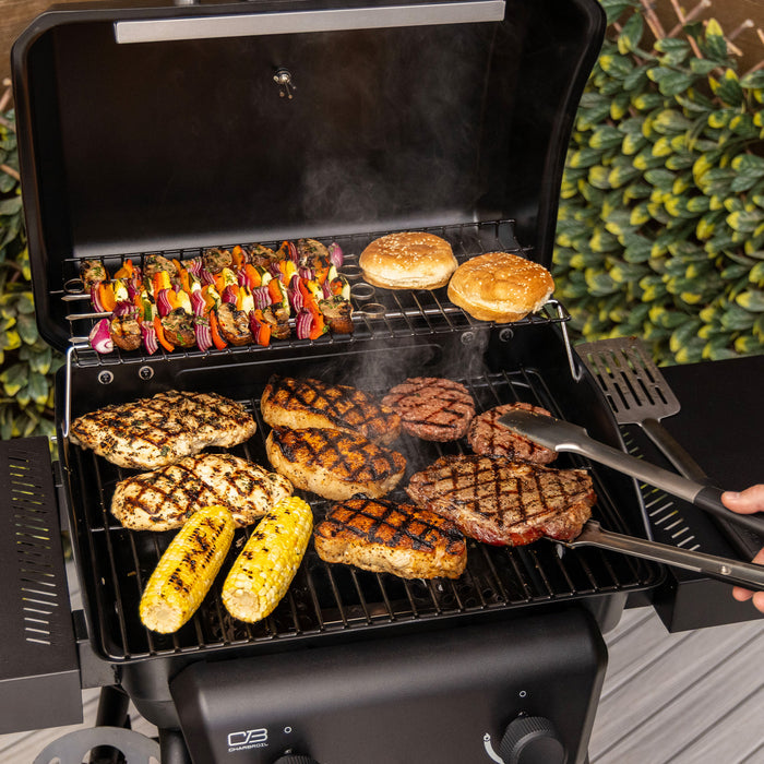 Black Char-Broil electric grill cooking burgers, steaks, corn, and skewers.