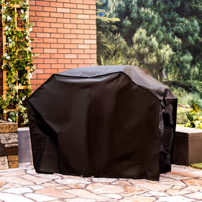 Black outdoor furniture cover on stone patio near brick wall and greenery.