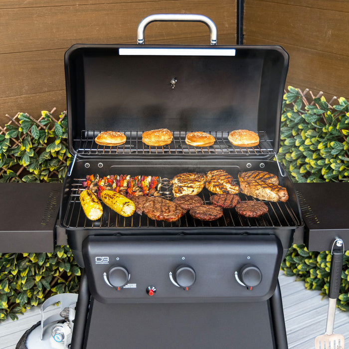 Black Char-Broil gas grill with burgers, steaks, and corn cooking on two racks.
