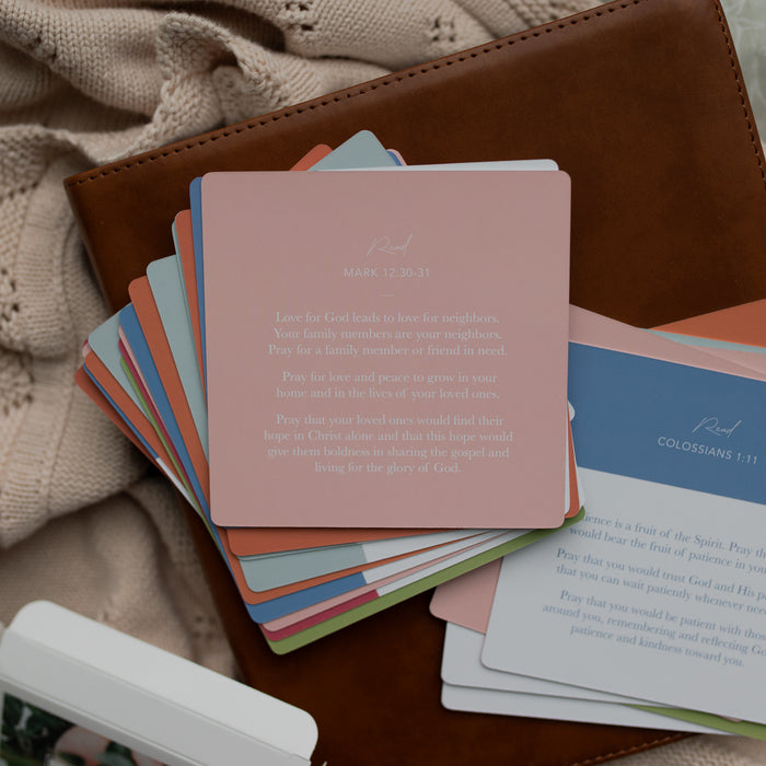 The back of the 31 Days of Prayer cards stacked on a leather bible on a cream colored blanket