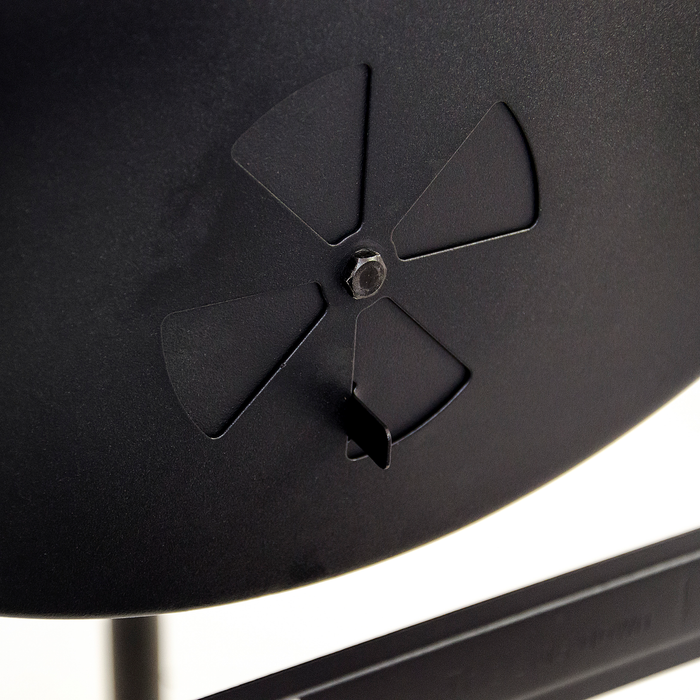Black device with four triangular cutouts around a central screw, likely for ventilation or mounting.