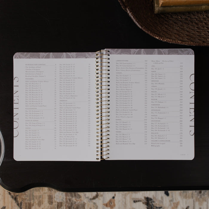 A Year in the bible Vol 3 opened to the table of contents page on a black tabletop