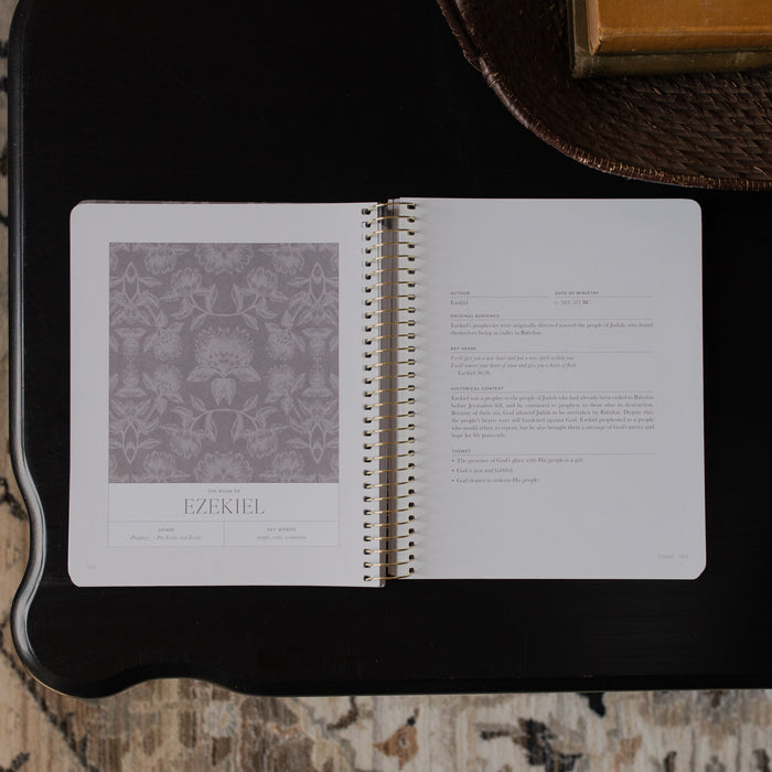A Year in the bible Vol 3 opened to the Ezekiel beginning page on a black tabletop