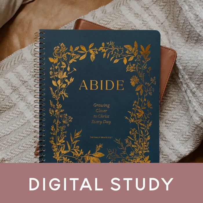 Notebook with floral design and 'Abide' text on a textured surface