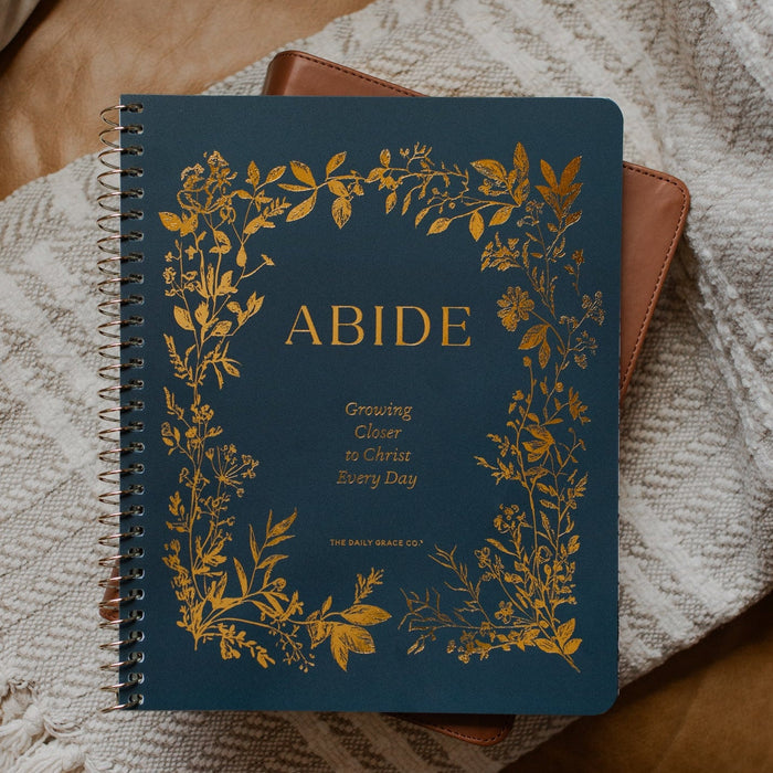 The Abide Spiral on a closed bible on a cream colored blanket