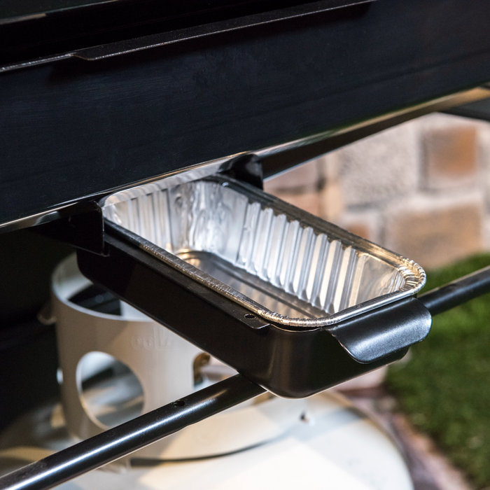 Black grill accessory with aluminum drip pan.
