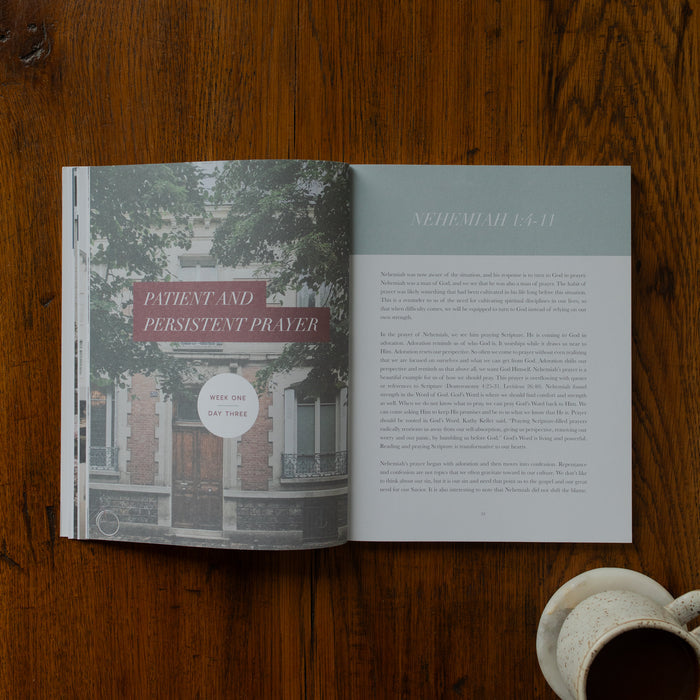 Open book on a wooden surface with text and a building illustration.