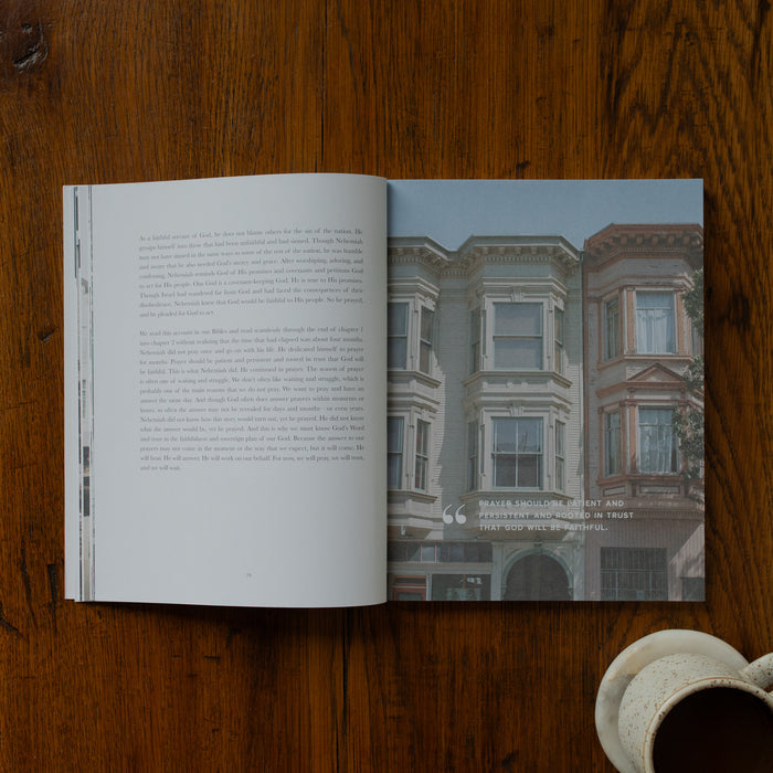Open book on a wooden surface with a photograph of a building on one page.