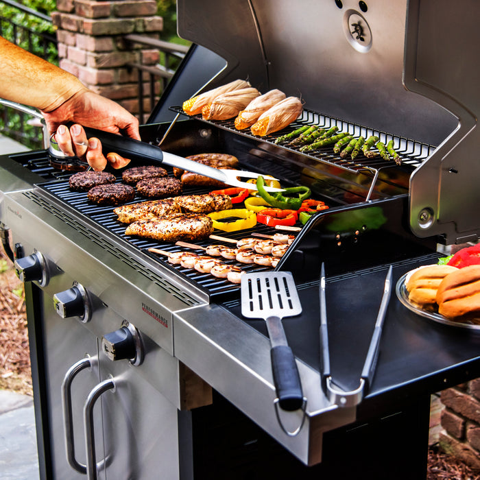 Silver outdoor grill with burgers, chicken, vegetables, and corn cooking.