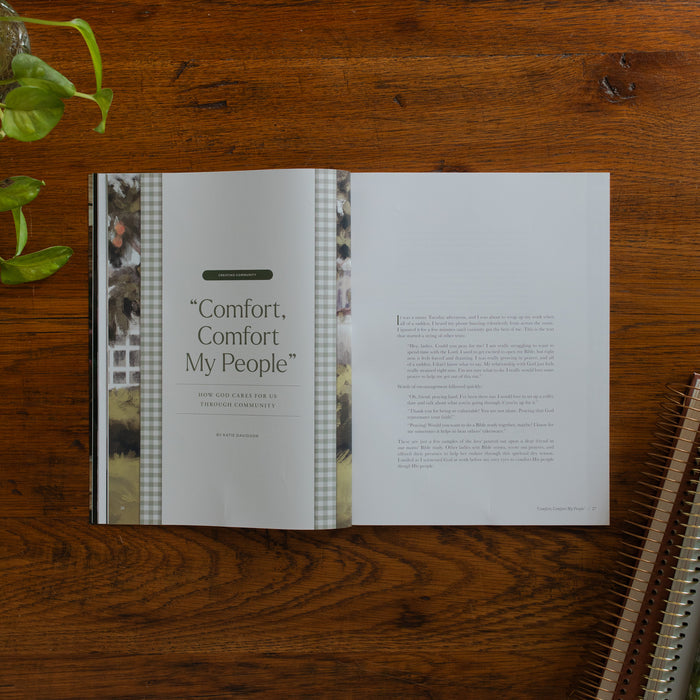 Be Still Issue 40 Magazine opened to the Comfort Comfort My People page on a wooden table near some greenery