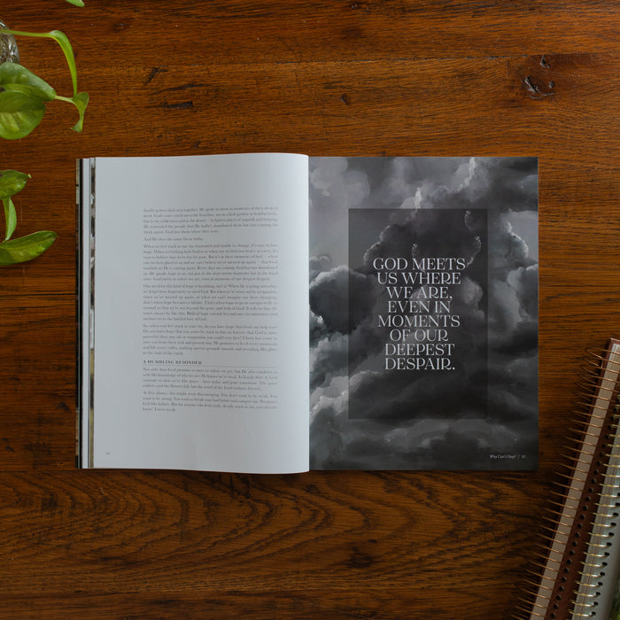 Be Still Issue 40 Magazine opened to the God meets us where we are page on a wooden table near some greenery