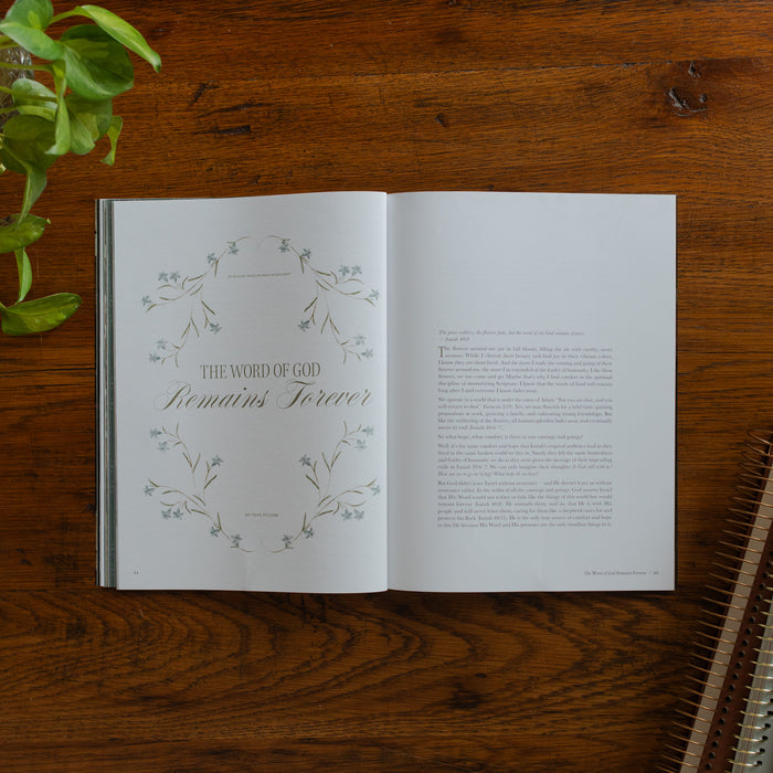 Be Still Issue 40 Magazine opened to the The Word of God remains forever page on a wooden table near some greenery