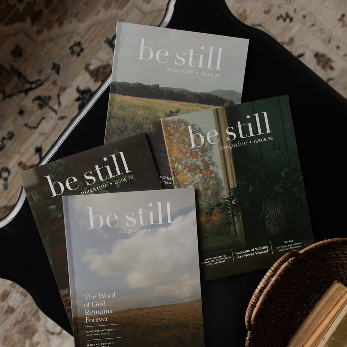 Be Still magazines stacked on one another on a black table