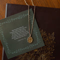 A beaded cross necklace on a verse card on a journal