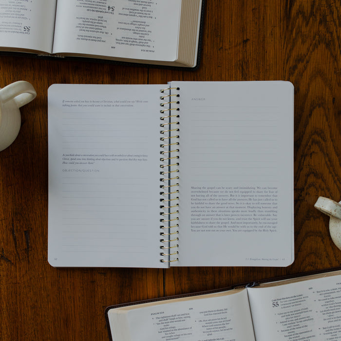 The Better Together Discipleship Guide opened to the Questions and Applications page on a wooden surface