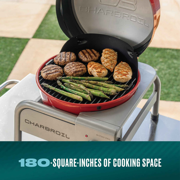 Red Char-Broil Bistro Pro electric grill with charcoal mode, cooking burgers, chicken, and asparagus.