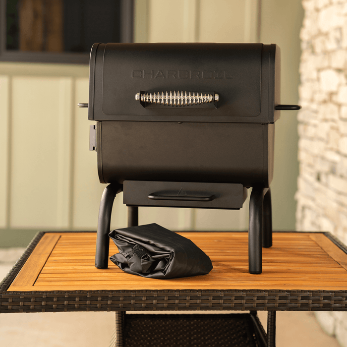 Black Char-Broil electric grill with charcoal mode on wooden table.