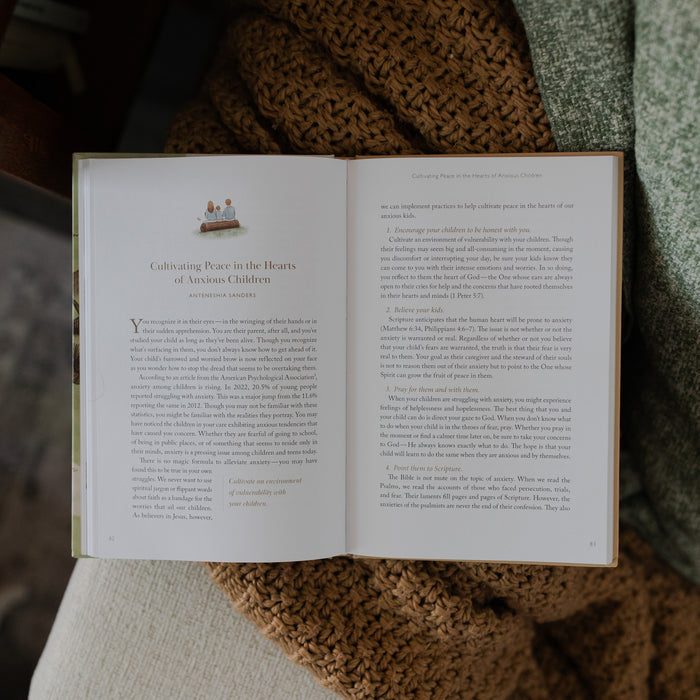 Christ Centered Family Book opened to Cultivating Peace in the hearts of anxious children page laying on on a brown knitted blanket resting on a creme colored couch