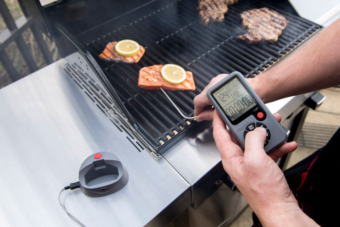 Smart thermometer with probe and charging dock for grilling and cooking.