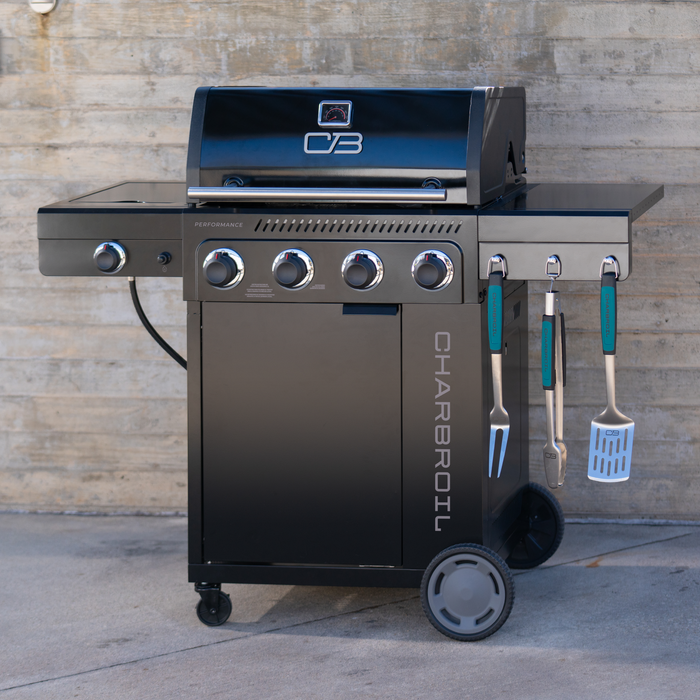Black Char-Broil Performance Series gas grill with four burners and cooking tools.