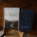 Two books titled 'The Bible Handbook' and 'Better Together' on a wooden surface.