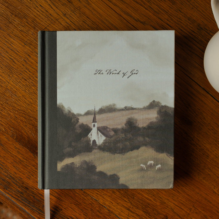 ESV Journaling Good Shepherd Bible cover on a wooden table next to a white coffee cup