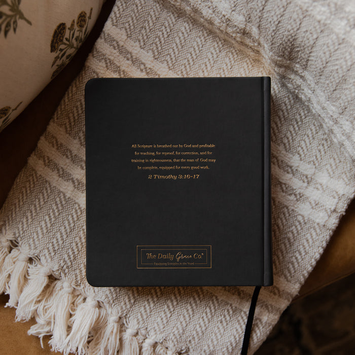 Black bible with text on a textured fabric surface