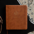 A leather ESV bible cover on a dark wooden table