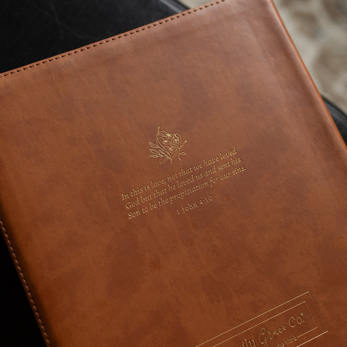 Up close of the back of A leather ESV bible cover on a dark wooden table