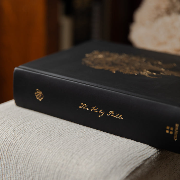 Black Bible with gold text on a textured surface