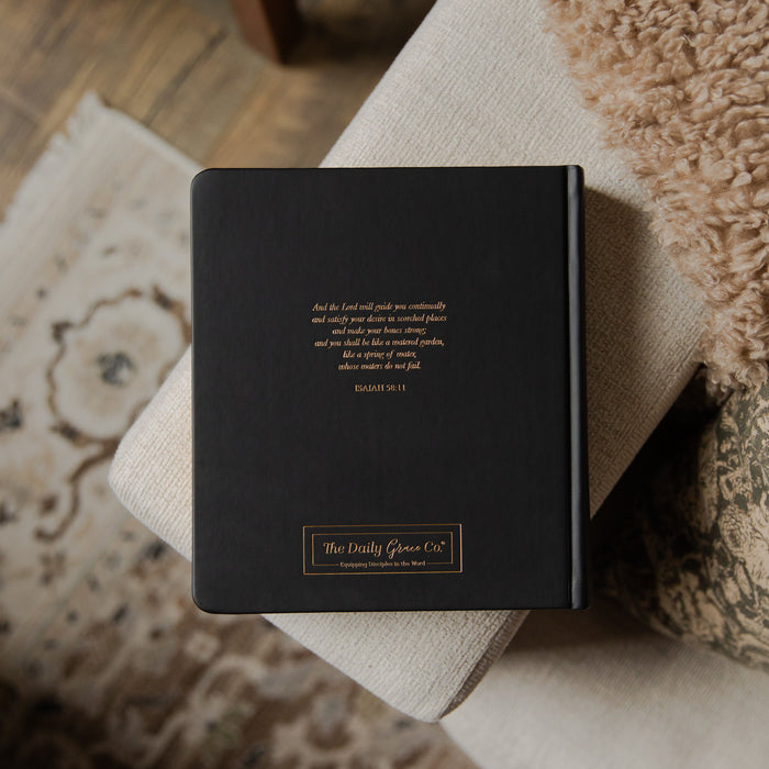 Black bible with gold text on a textured surface