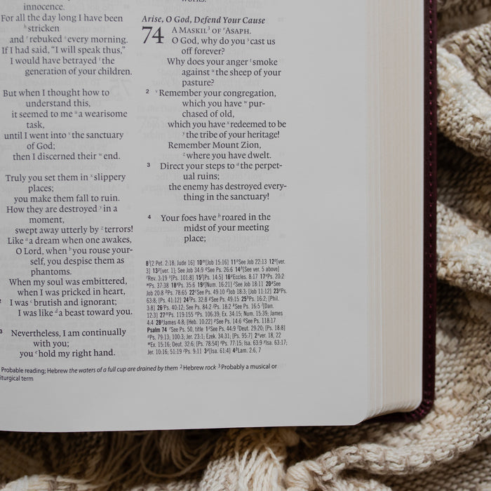 an open leather bible opened to Psalms 74 up close on a textured blanket