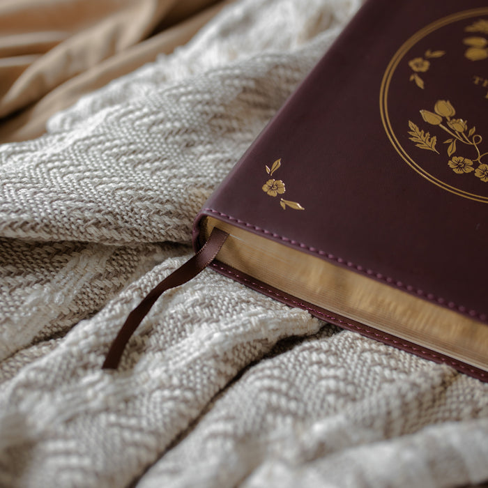 leather bible with gold etching up close of the tassle on a textured blanket