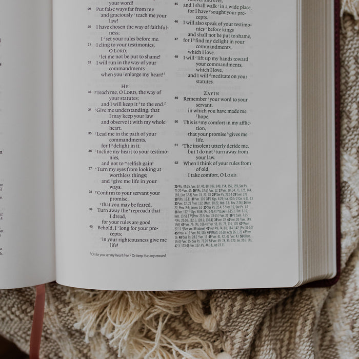 An open bible close up to the corner on a textured blanket