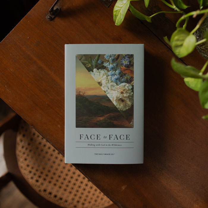 Face to Face Hardcover on a wooden table near some greenery