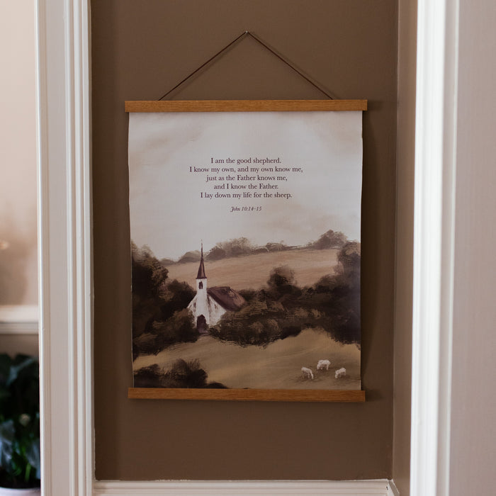 The Good Shepherd Canvas Print hanging on a brown wall with white trim