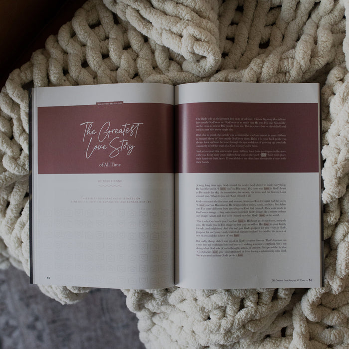 Gospel at Home Issue 7 opened to the greatest love story page on a white knitted blanket