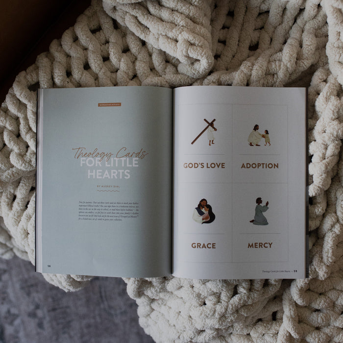 Gospel at Home Issue 7 opened to the theology cards for little hearts page on  a white knitted blanket