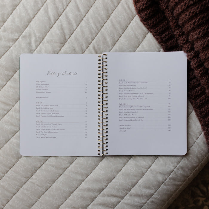 Open spiral-bound notebook on a textured surface with a list of contents visible