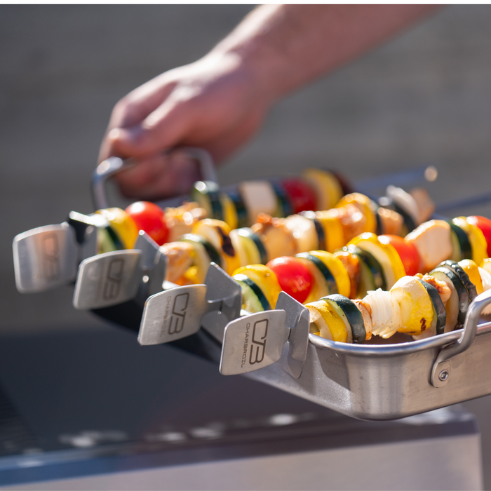 Silver Char-Broil skewers holding colorful vegetable kabobs.