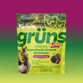 Yellow-green Shrek Kids Grüns Superfoods Greens Gummies package featuring Shrek and Donkey, labeled Berry Far Far Away flavor, listing Daily Essentials, Supports Developmental Growth, Yummy Taste, Dietary Supplement, 28 Daily Packs, for ages 2 to 13, on a purple-to-green gradient background.