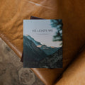 He Leads Me Mens Study Cover on a leather couch seat