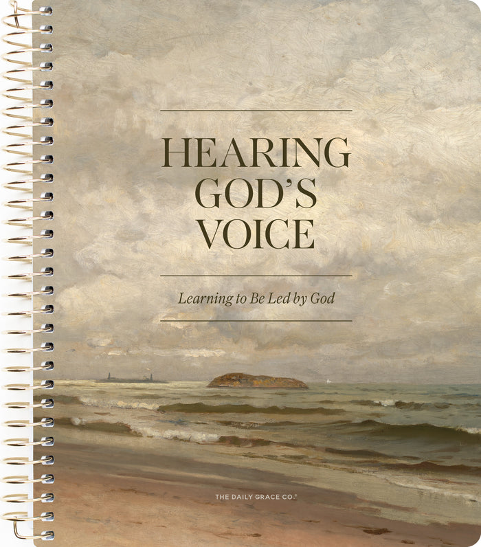 A spiral-bound book or journal cover featuring a seascape painting with the title 'HEARING GOD'S VOICE' and the subtitle 'Learning to Be Led by God.' The bottom text reads 'THE DAILY GRACE CO.