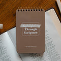 Highlighting through Scripture flipbook on an open bible on a wooden table near some highlighters