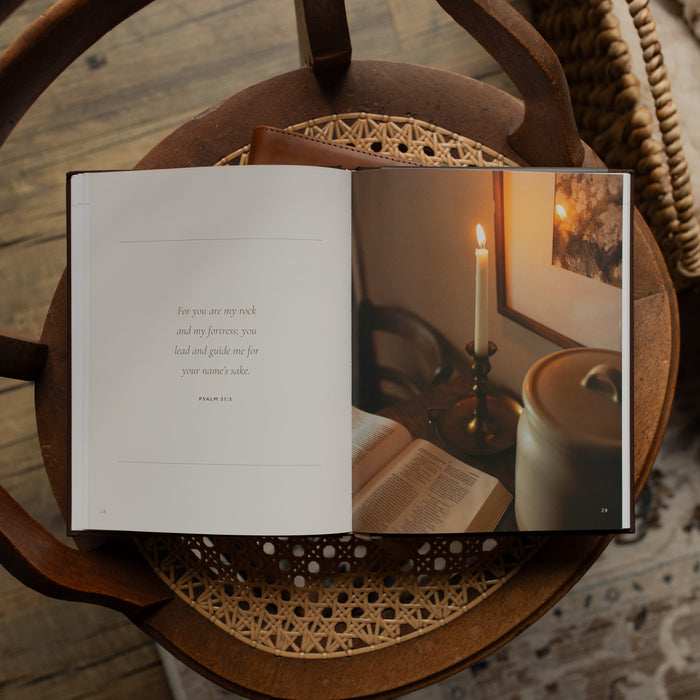 The I need Thee Every Hour book opened to the For you are my rock Psalm 31:3 page on a wicker chair