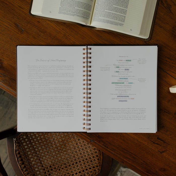 Identity in Christ Verse Map Journal opened to the basics of verse mapping page on a wooden table near a coffee mug and an open bible