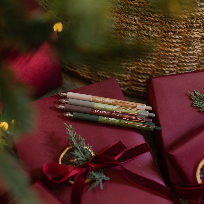 All four of the Identity Pen Set on an red package wrapped with a red ribbon