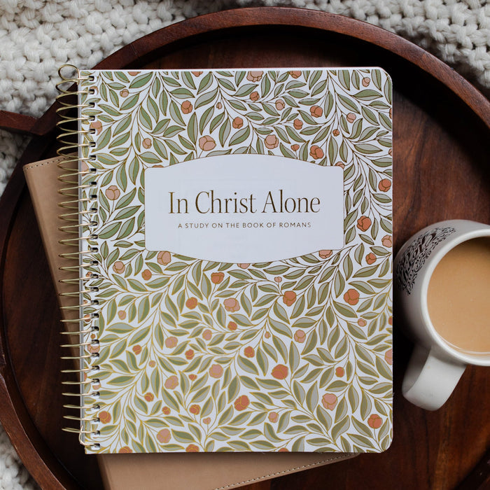 In Christ Alone Study Cover on a Bible next to a white coffee cup on a wooden tray on a knitted blanket