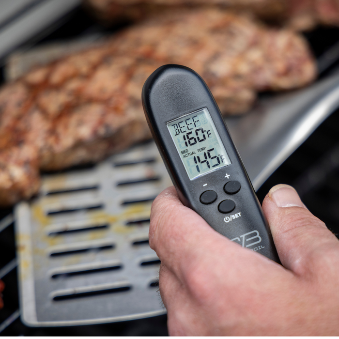 Black digital meat thermometer displaying "BEEF 160°F" and "ACTUAL TEMP 145°F" in use on cooked meat.