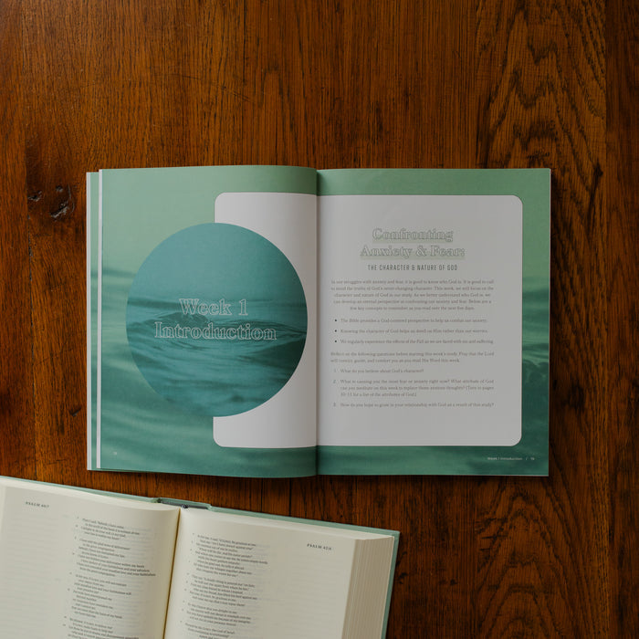 It is Well Teen Study opened to the week 1 introduction page on a wooden table next to an open bible